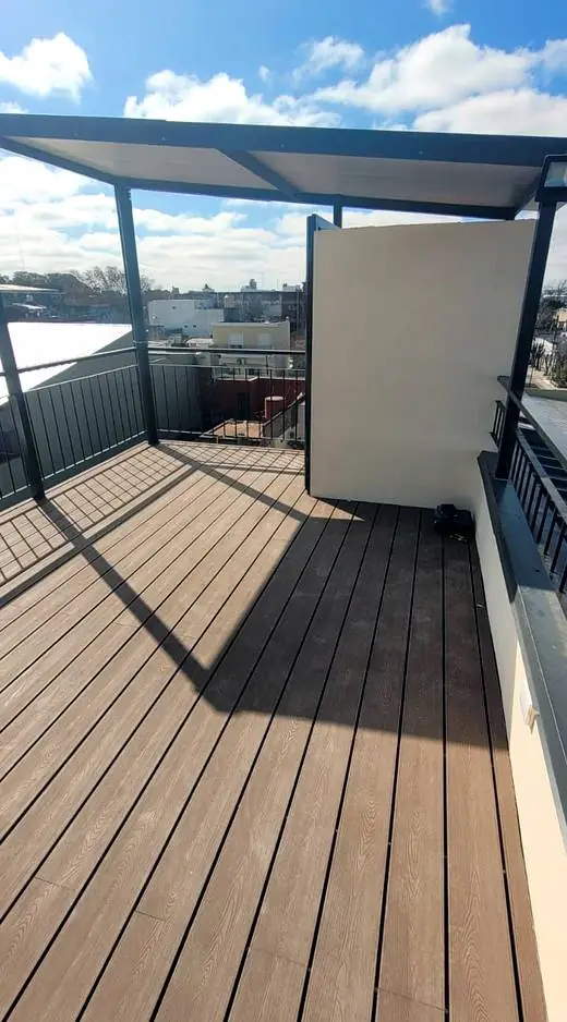Deck de madera compuesta terminado bajo pérgola metálica