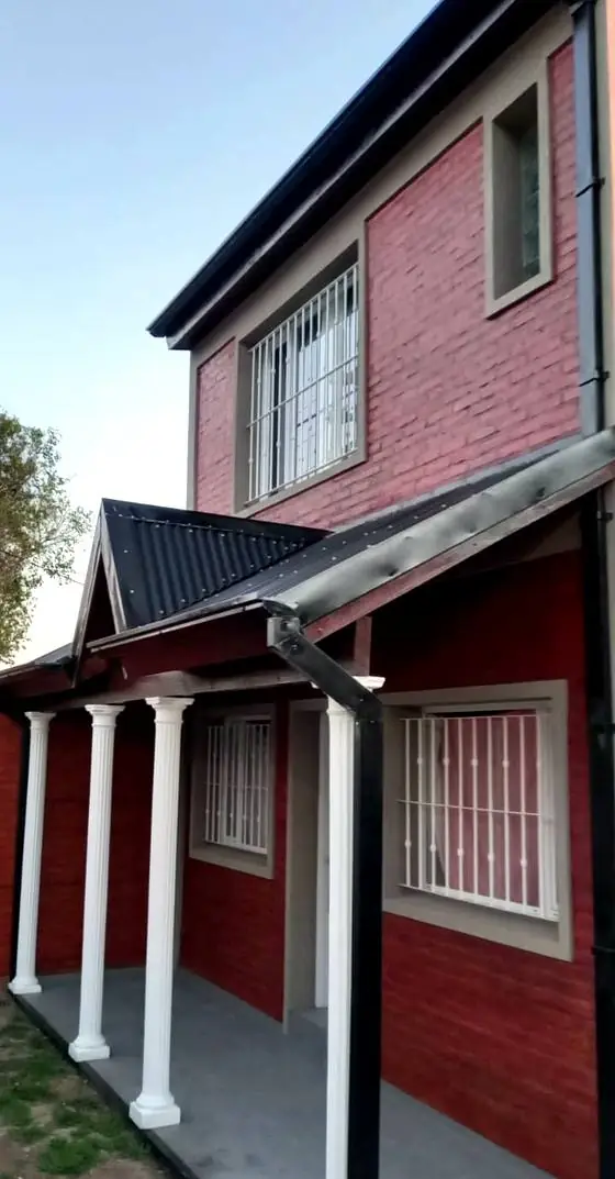 Galería exterior con columnas y frente de ladrillo visto