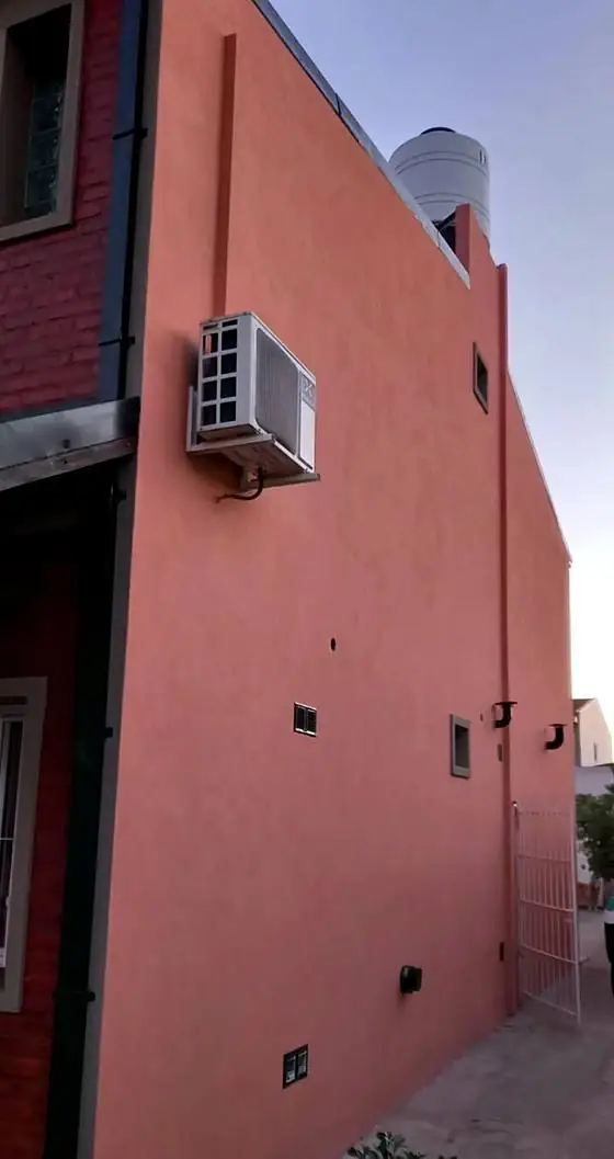 Medianera revocada y pintada al atardecer