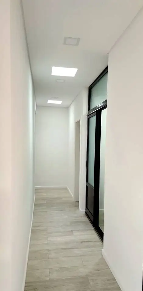 Pasillo interior terminado con piso símil madera y puerta corrediza vidriada