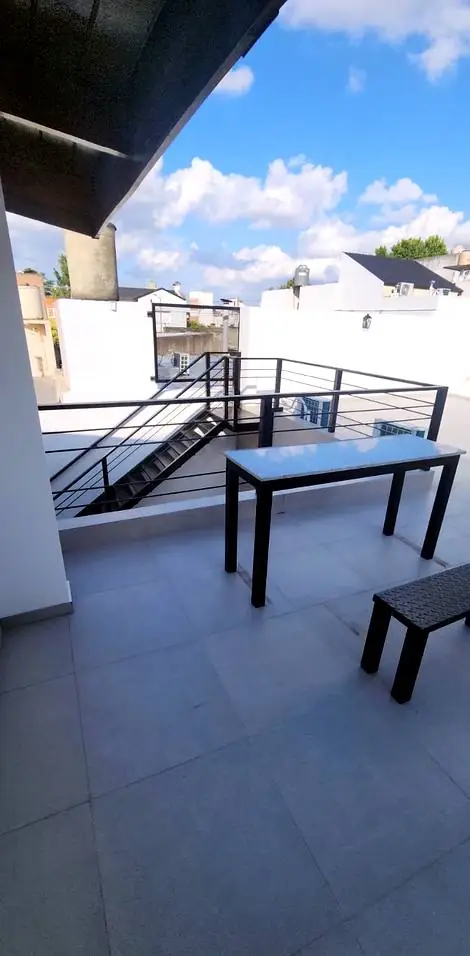 Terraza terminada con mesa, banco y escalera de acceso